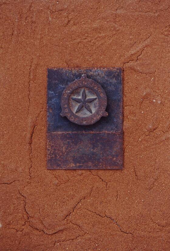 Rust-red surface with a violet plate bearing a rusty star.