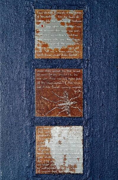Blue, textured surface with three square rust plates, partly with white handwriting and drawing.