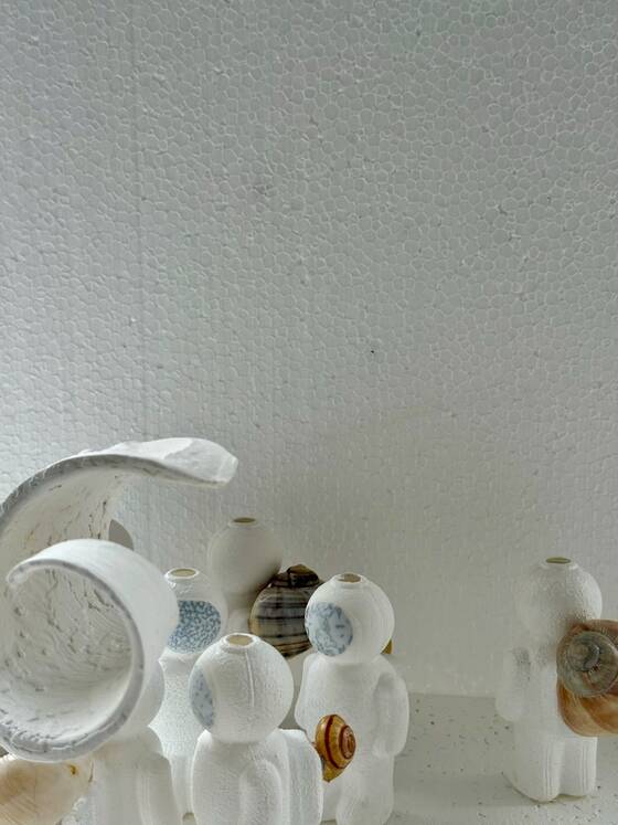 UStronauts with snail shells beneath a curved white form.
