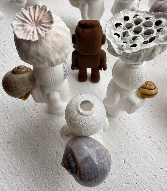 Figures with a poppy capsule and a lotus pod on their heads, a RAWbot in the middle.