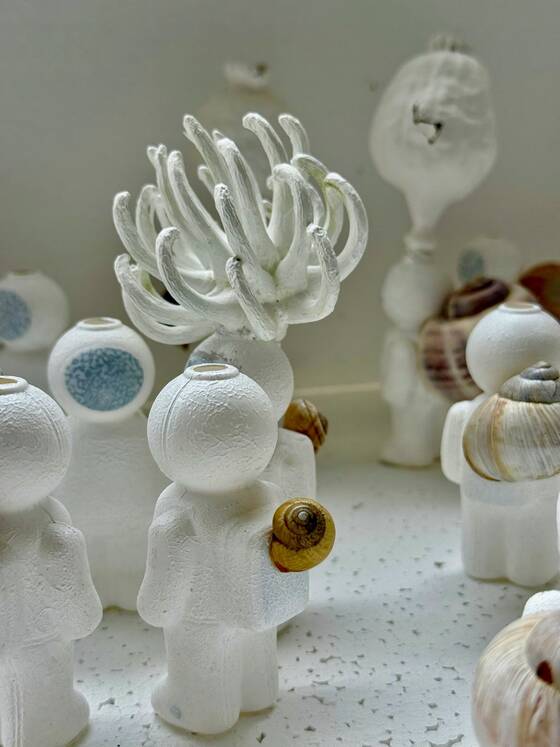 UStronauts with a coral-like form on their heads, more figures behind them.